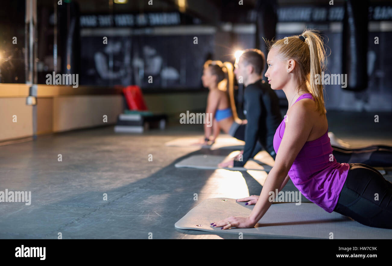Young athletic people doing pilates stretching excercises Stock Photo