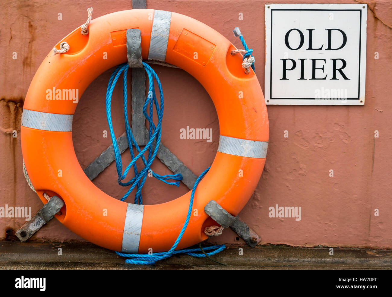 An Old Pier sign and lifebelt in a harbour Stock Photo