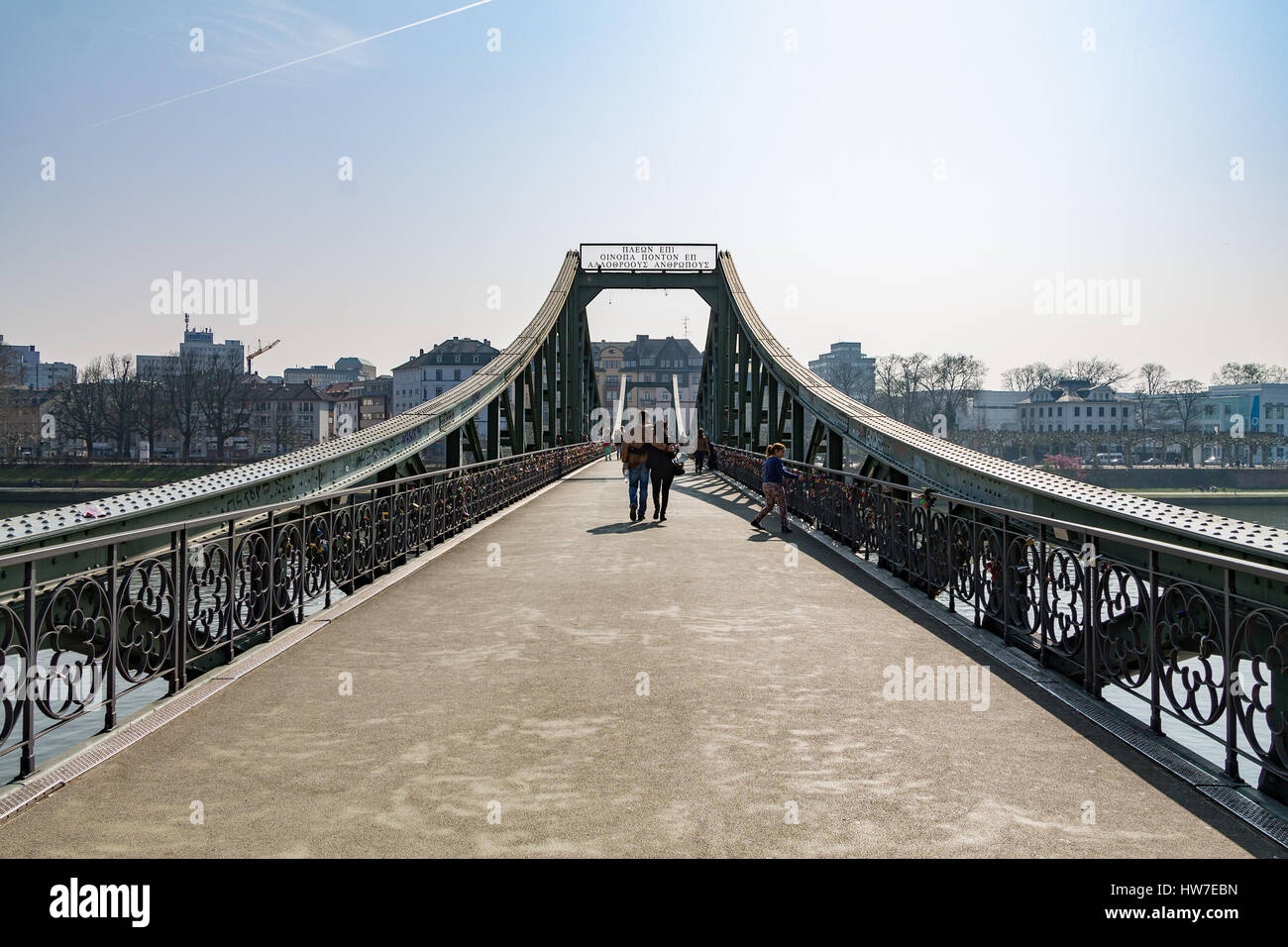 A couple walking across the Eiserner Steg in Frankfurt during the day Stock Photo