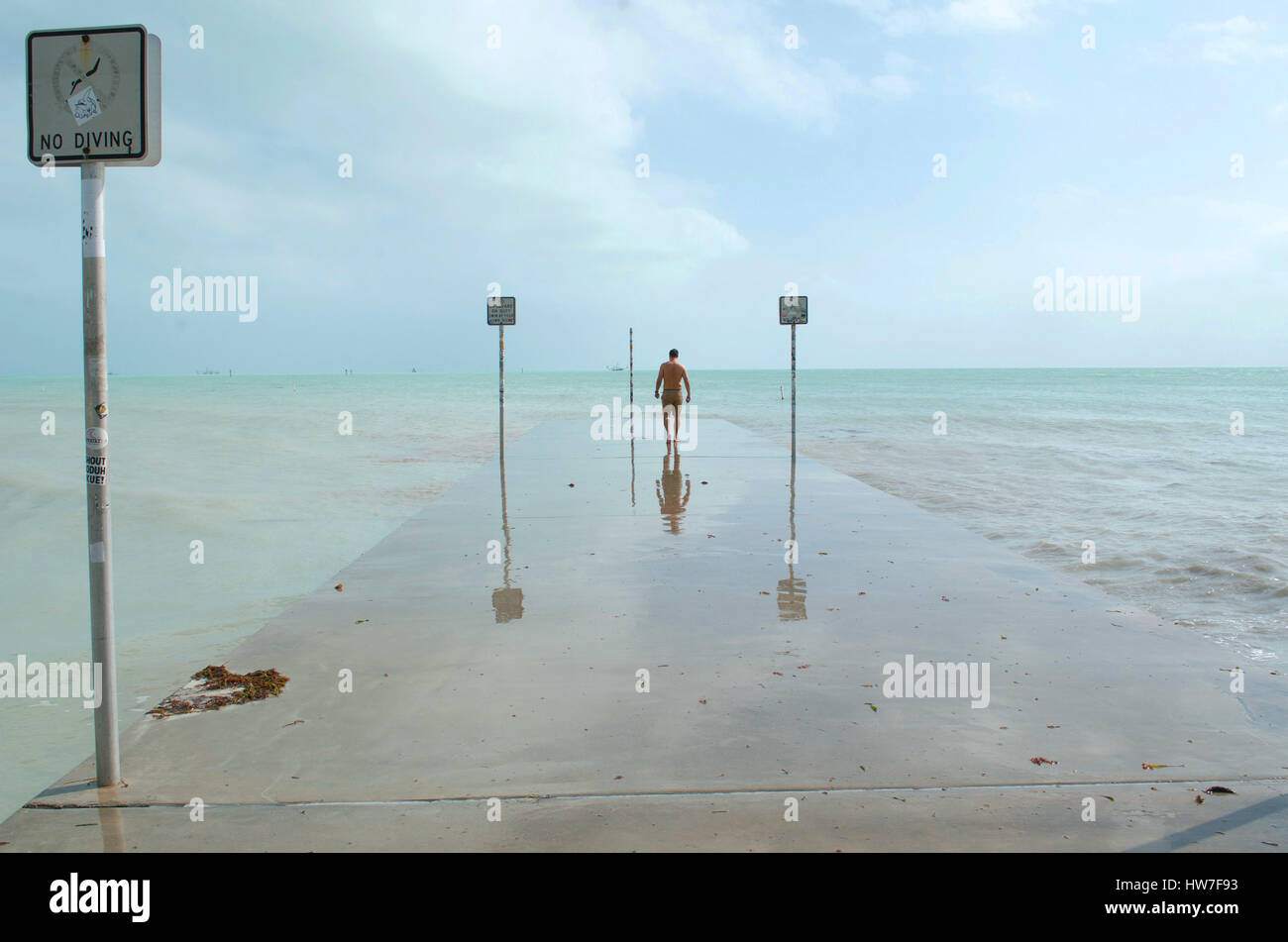 A man walks to the end of a cement pier in Key West Stock Photo Alamy