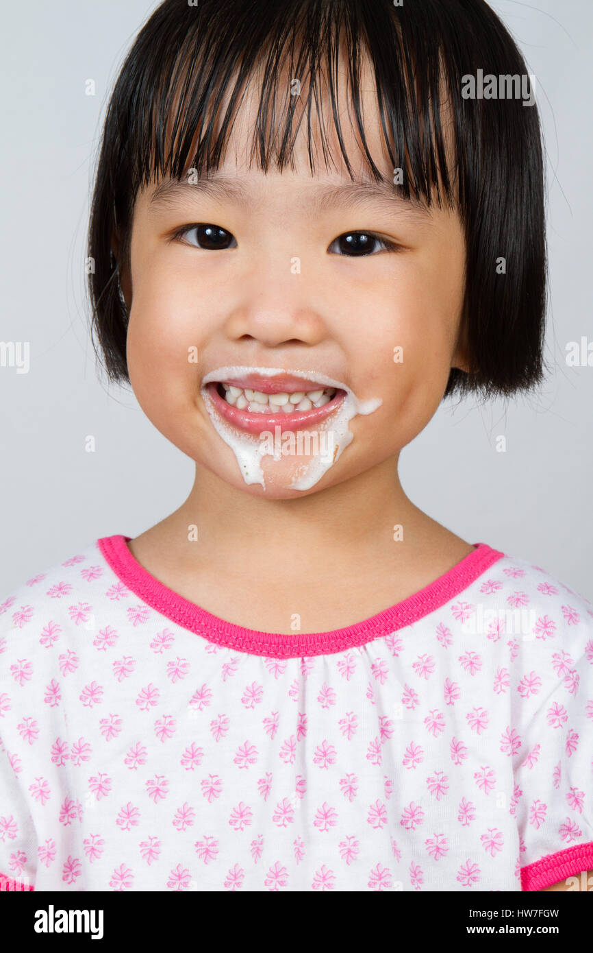 Asian Little Chinese Girl Eating Ice Cream isolated on White Background Stock Photo