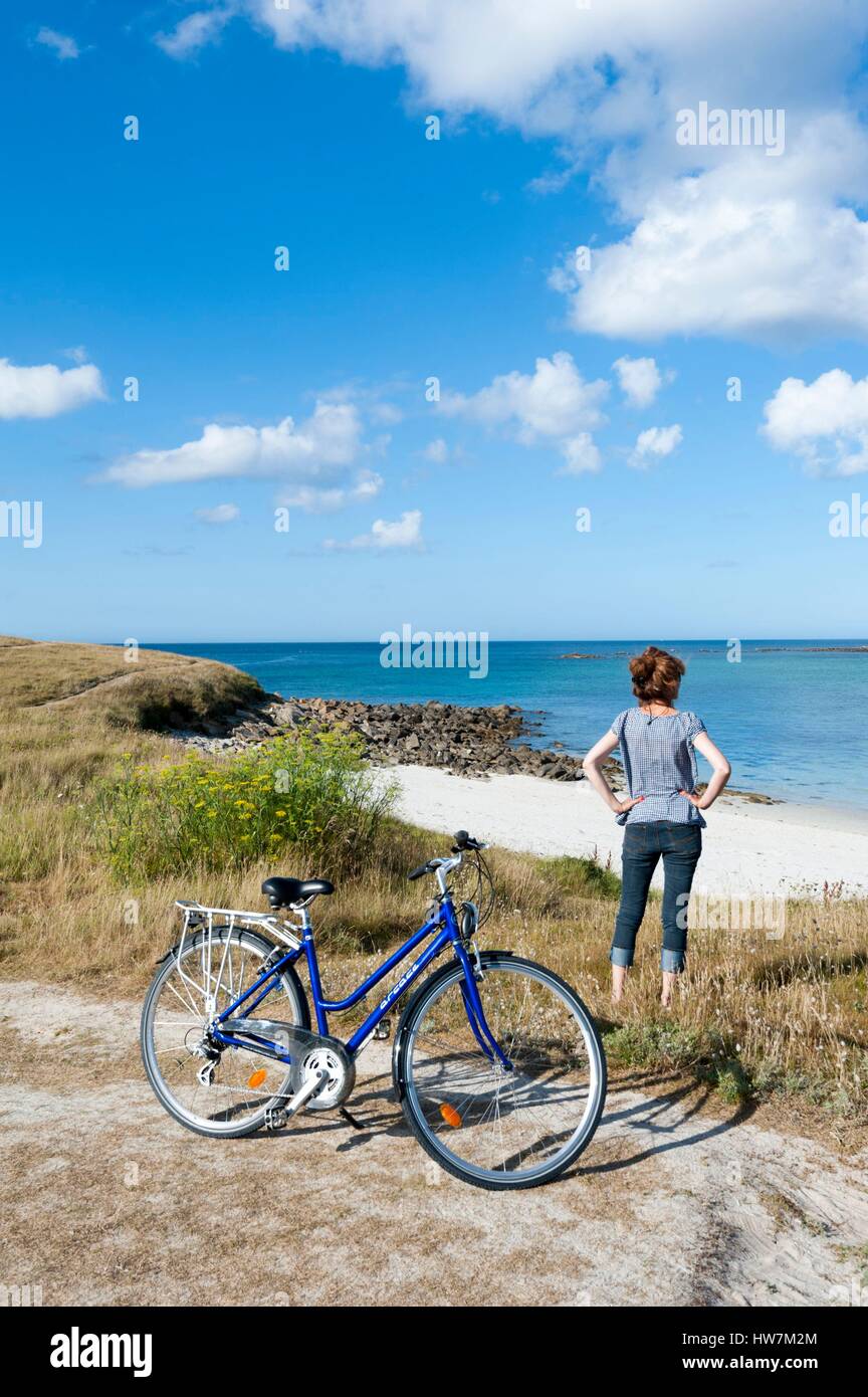 France, Finistere, Ponant islands, island of Batz, Cycling woman on the coast Stock Photo