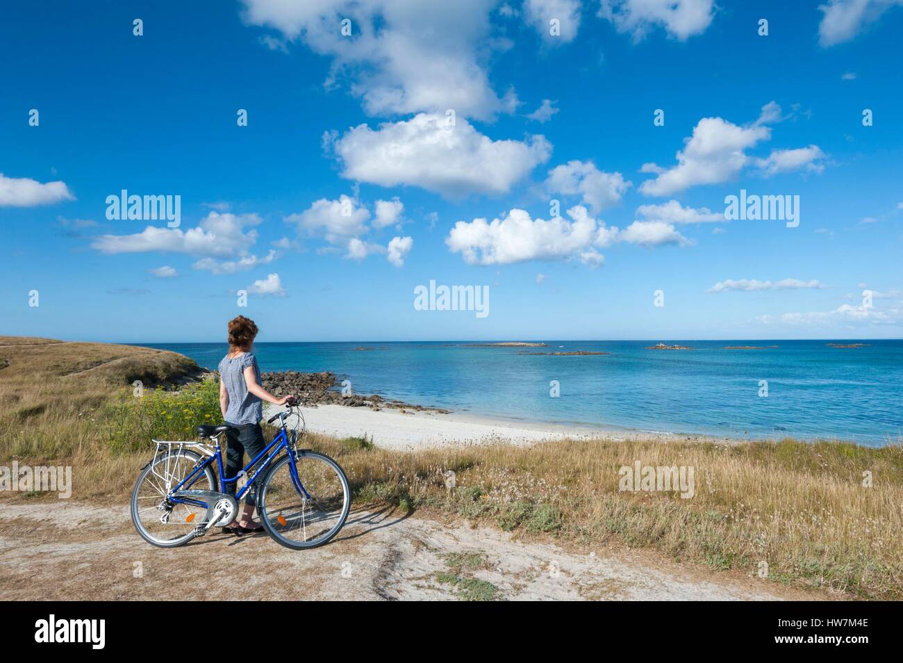 France, Finistere, Ponant islands, island of Batz, Cycling woman on the coast Stock Photo