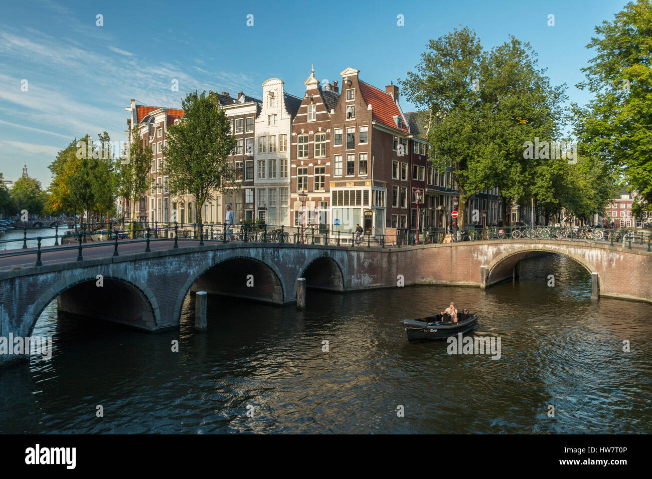 AMSTERDAM, NETHERLANDS- SEPTEMBER 27, 2016: Bridges, bikers and boaters at the intersection of the Keizersgracht and Leidsegracht Canals. Stock Photo