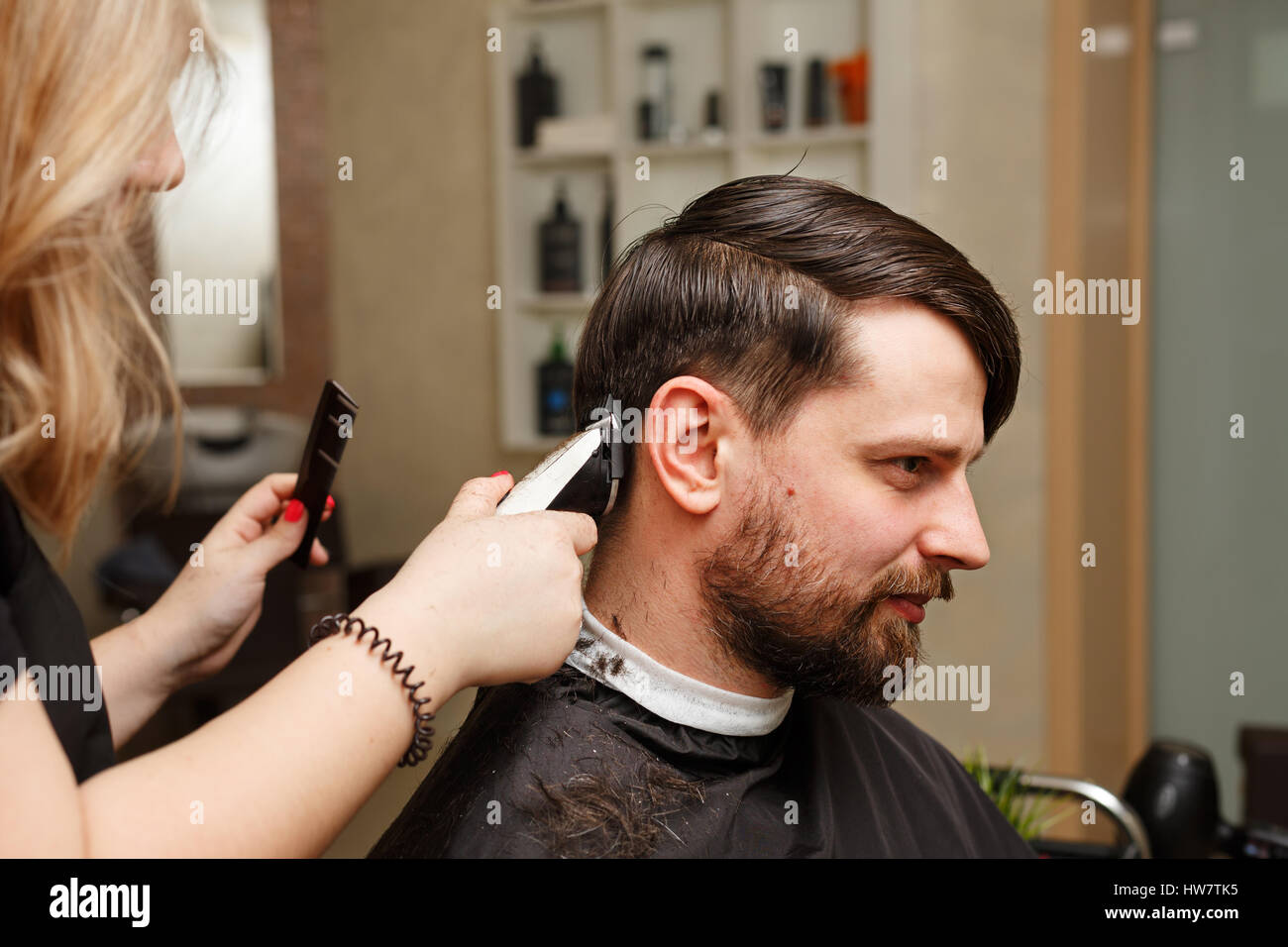 Professional hairdresser doing haircut men's hair. Cutting electric razor.  Beauty saloon. Male beauty. The client is a hipster Stock Photo - Alamy