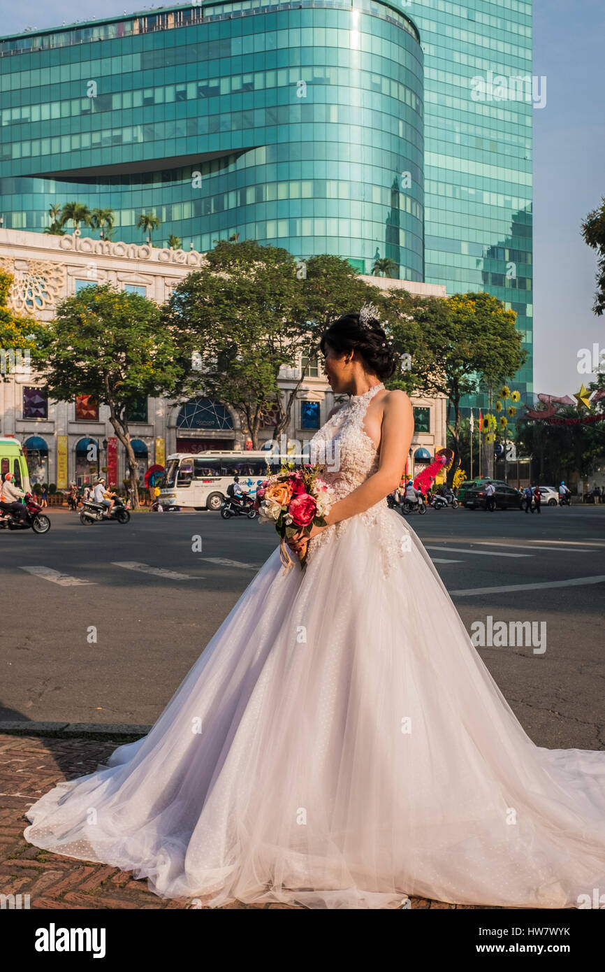 Bride in white dress poses for photograph in the street, Ho Chi Minh City, Vietnam Stock Photo