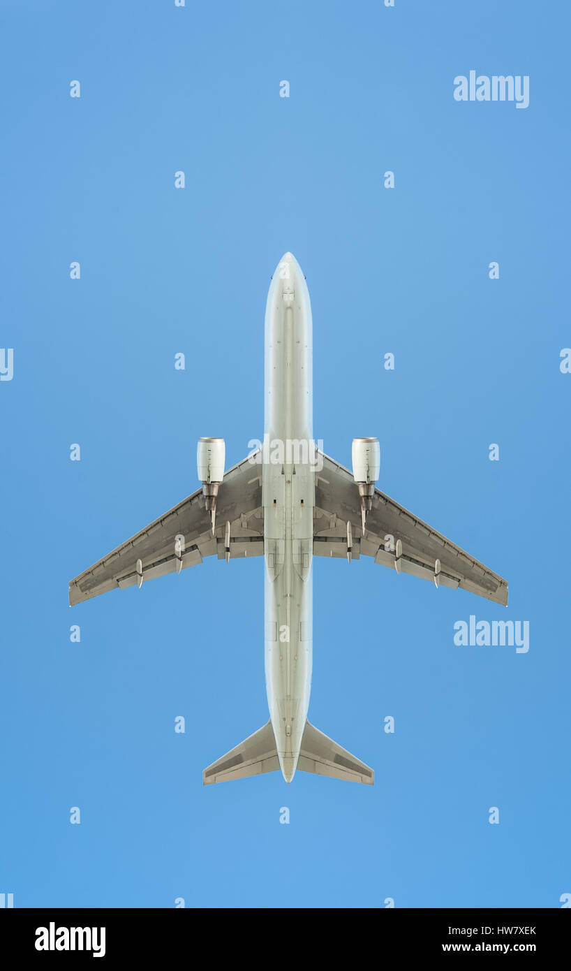 passenger jet silhouette against a clear blue sky Stock Photo