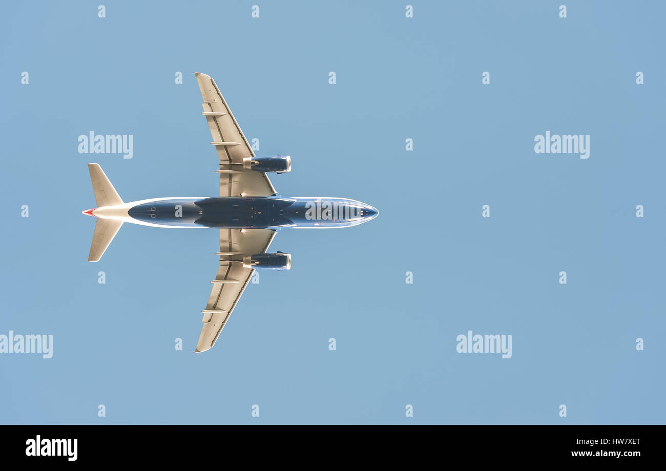 passenger jet silhouette against a clear blue sky Stock Photo