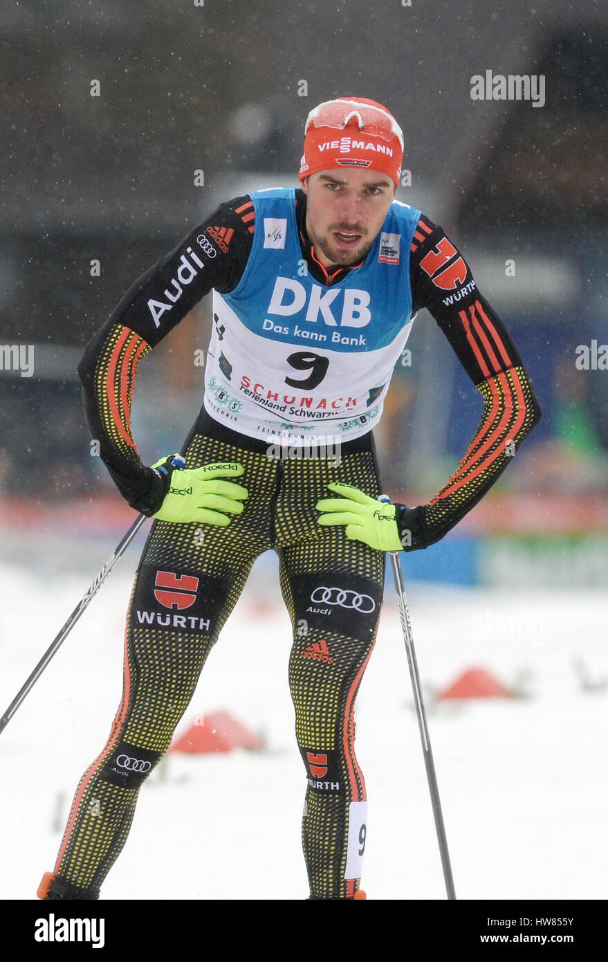 Schoenach, Germany. 18th Mar, 2017. Johannes Rydzek from Germany arrives at the finish line at third place after falling shortly before reaching the end during the men's single on the large hill/10km cross-country at the Nordic Combined World Cup in Schoenach, Germany, 18 March 2017. Photo: Patrick Seeger/dpa/Alamy Live News Stock Photo