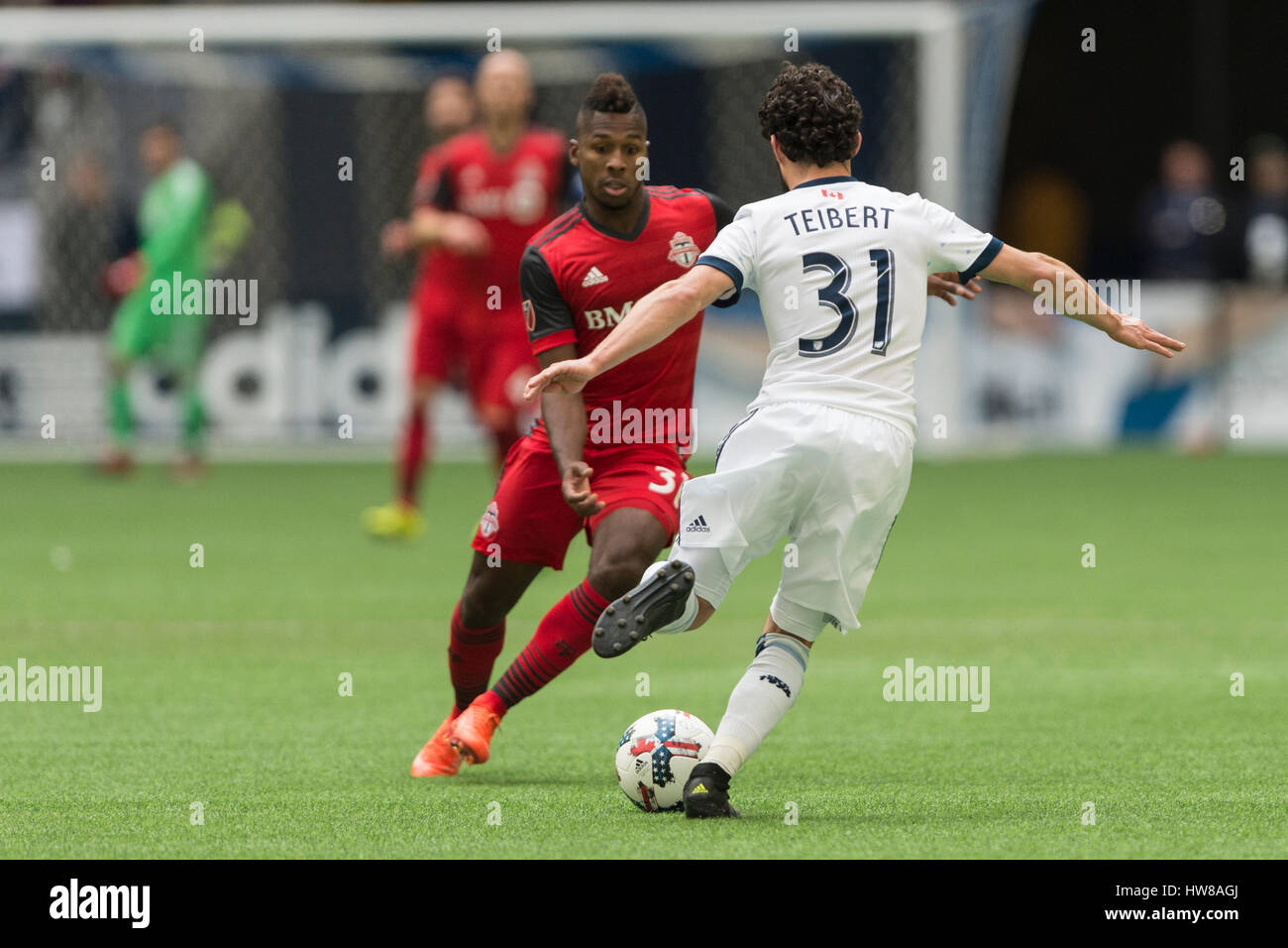 Vancouver, Canada. 18 March, 2017. Russell Teibert #31 of the Vancouver Whitecaps with Armando Cooper #31 of Toronto FC about to challenge him. Vancouver Whitecaps vs Toronto FC, BC Place Stadium. Toronto defeats Vancouver 2-0, with goals from Victor Vasquez #7 and Jozy Altidore #17 of Toronto FC  © Gerry Rousseau/Alamy Live News Stock Photo