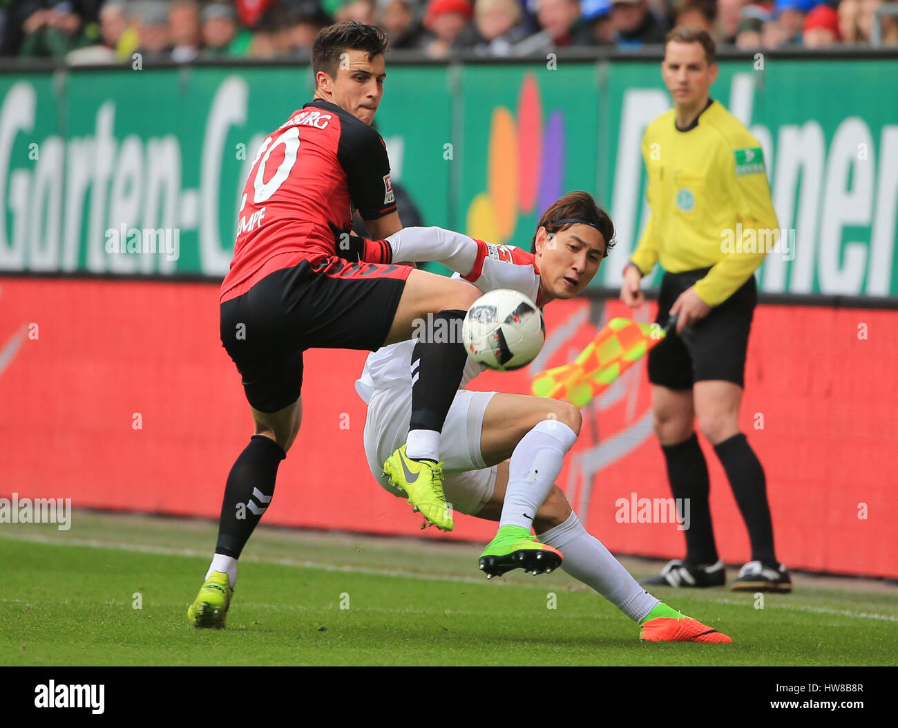 Augsburg, Germany. 18th Mar, 2017. Augsburg's Ji Dong-Won (R) vies with Freiburg's Marc-Oliver Kempf during a German Bundesliga match between FC Augsburg and SC Freiburg in Augsburg, Germany, on March 18, 2017. The match ended in a 1-1 draw. Credit: Philippe Ruiz/Xinhua/Alamy Live News Stock Photo