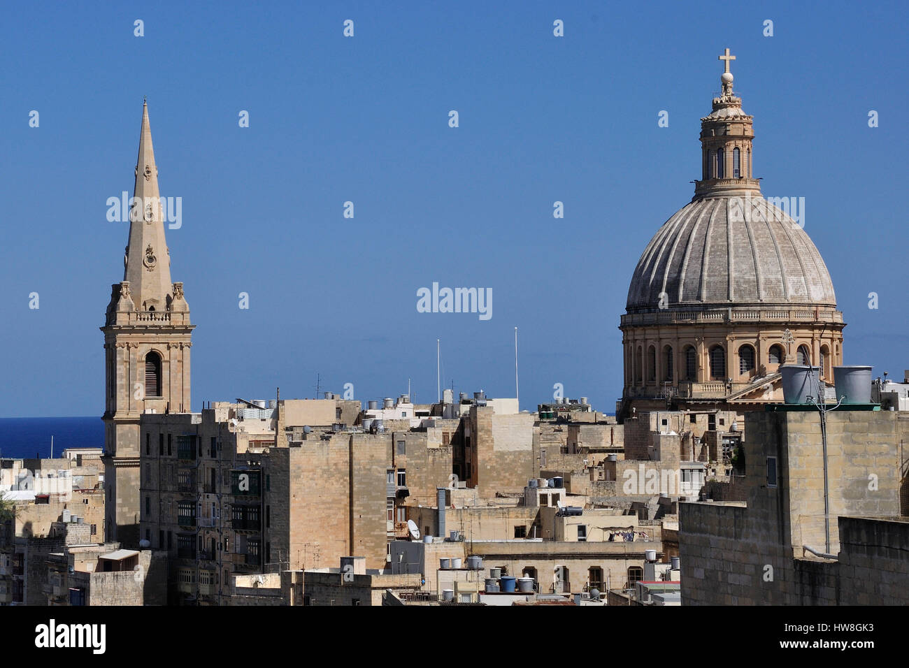 view over rooftops towards two iconic Maltese religious sites,St Pauls Anglican pro-cathedral and the Catholic Our Lady of Mount Carmel,clear blue sky Stock Photo
