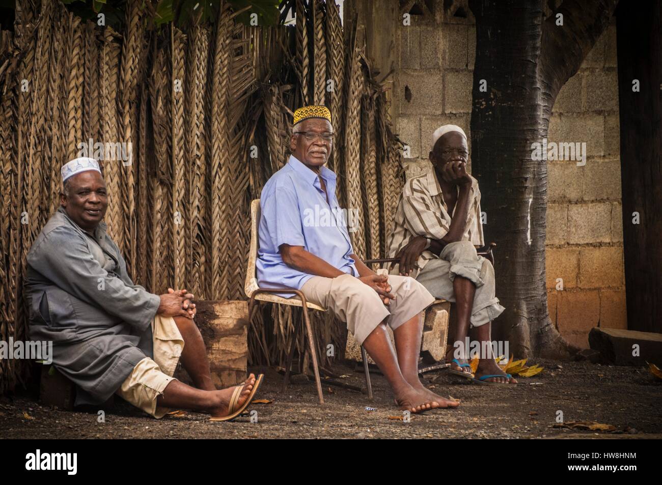 France, Mayotte island (French overseas department), Grande Terre, Mamoudzou, 3 men wearing their kofia, embroidered traditional hat from Comoros, discuss on the sidewalk just outside the mosque Stock Photo