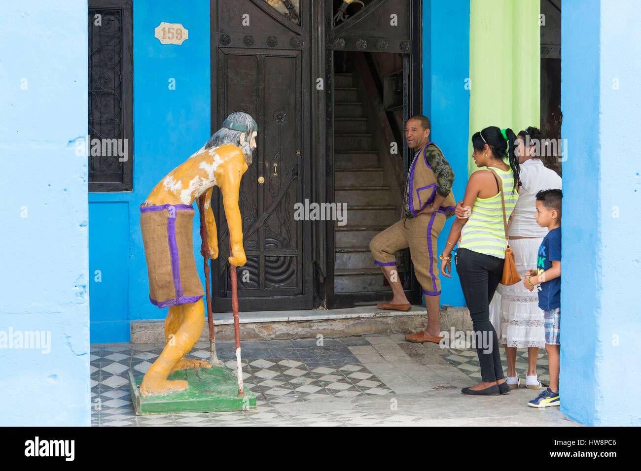 Cuba, Ciudad de la Habana province, Havana, Centro Habana district, people with a statue of San Lazaro standing by the facade of a house. San Lazaro is the second most celebrated Saint in Cuba after the Virgen de la Caridad especially by Santeria believers Stock Photo