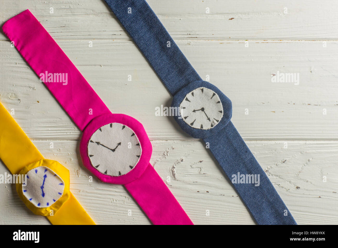 Three Rag Wristwathes in Row on Wooden Background Stock Photo - Alamy