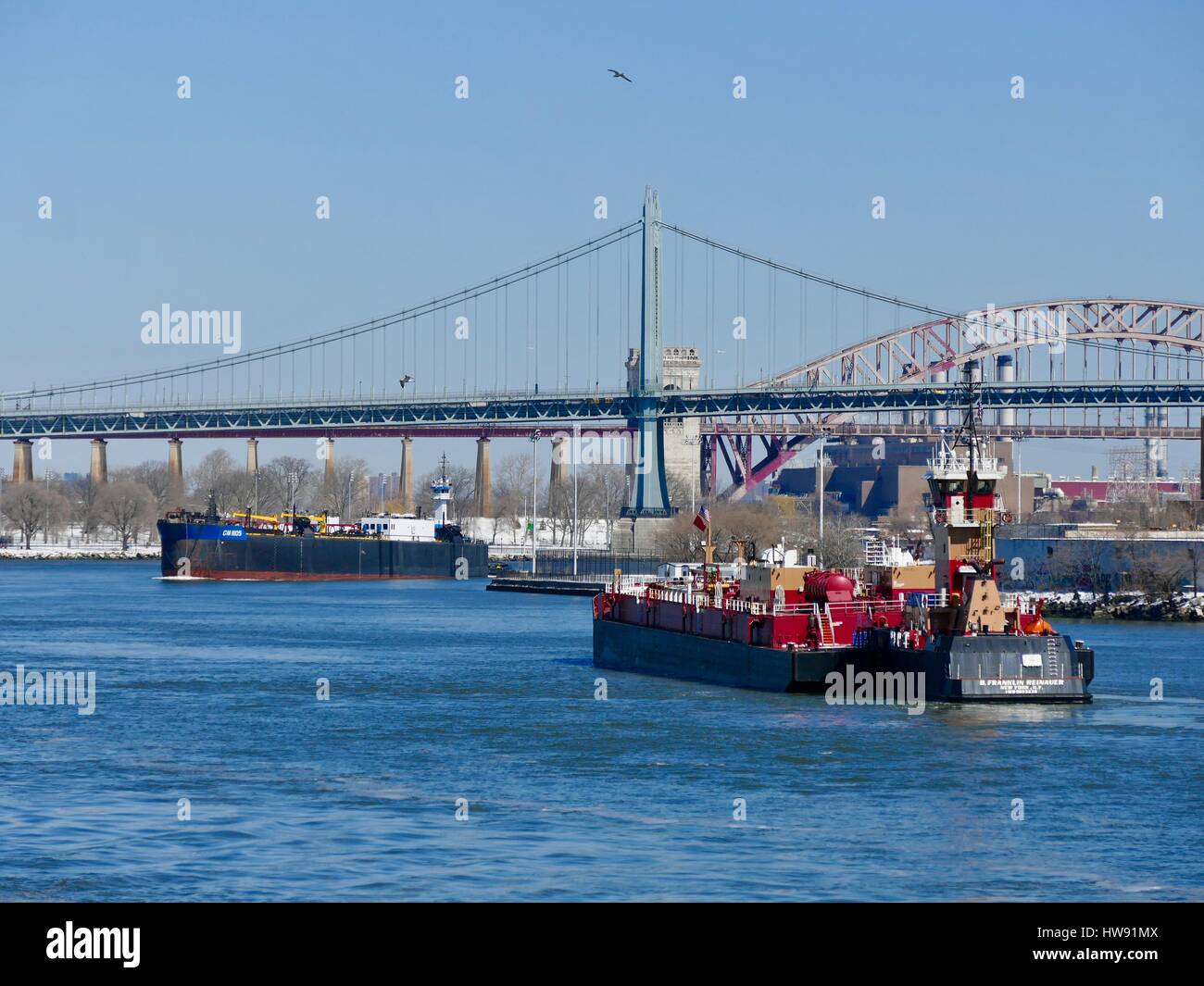 East River commercial boat traffic with RFK bridge in background. New York City, New York, USA Stock Photo