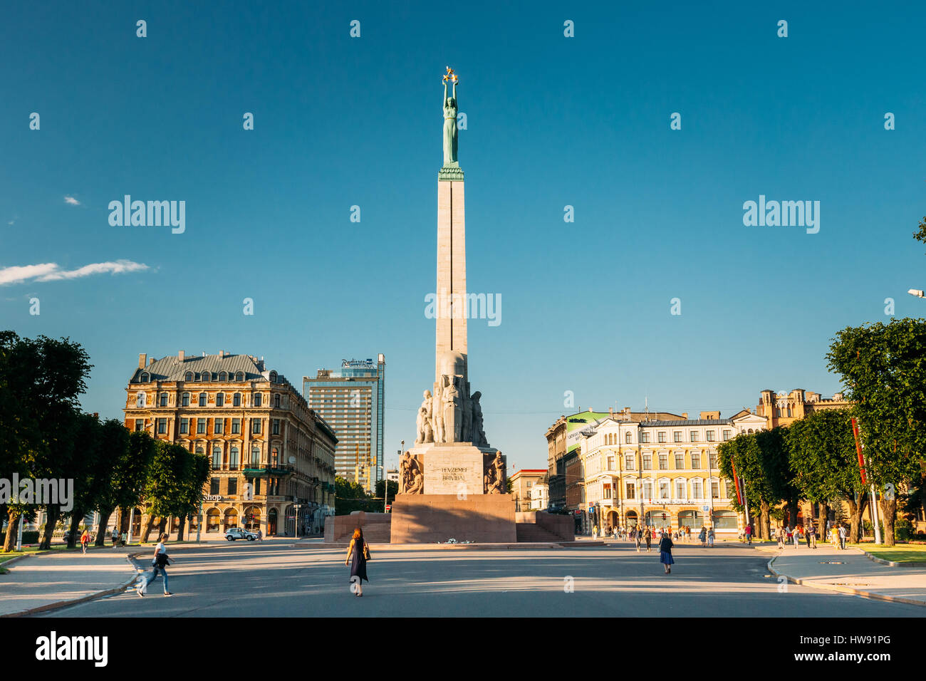 Riga, Latvia - July 1, 2016: People Walking Near Memorial Freedom Monument At Freedom Square In Sunny Summer Day. Famous Landmark. Stock Photo