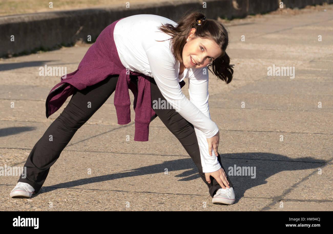 Little girl doing exercises in park Stock Photo