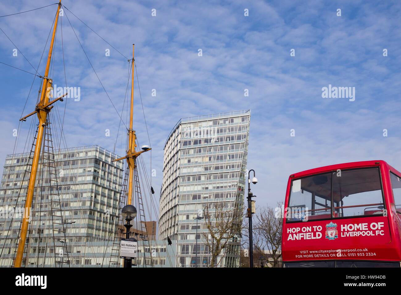 Tall boat mast and red tour bus in contrast to modern office blocks in Liverpool Stock Photo