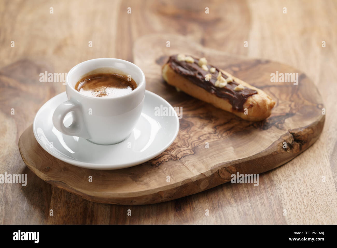 fresh espresso and eclair with hazelnuts Stock Photo