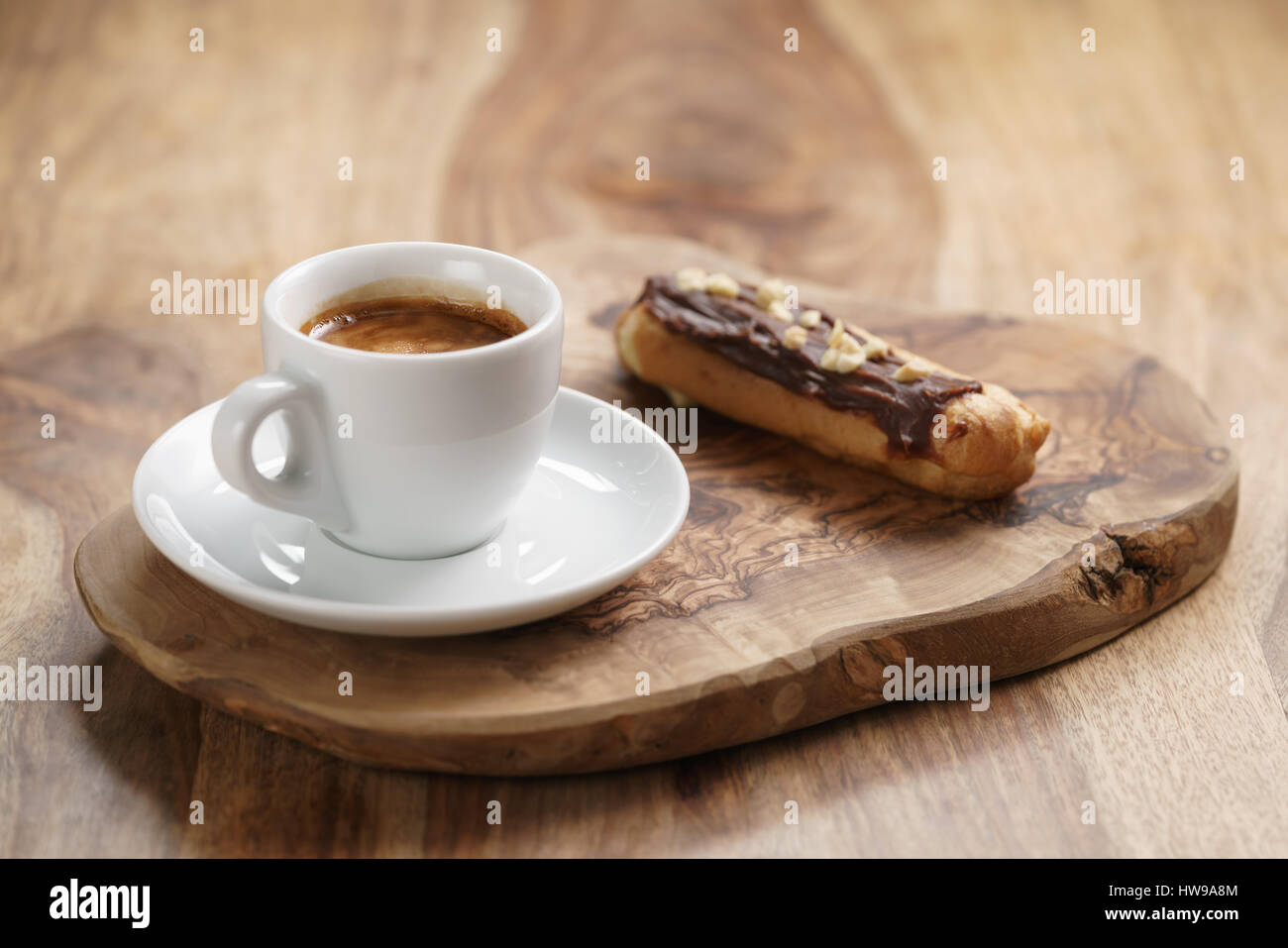 fresh espresso and eclair with hazelnuts Stock Photo