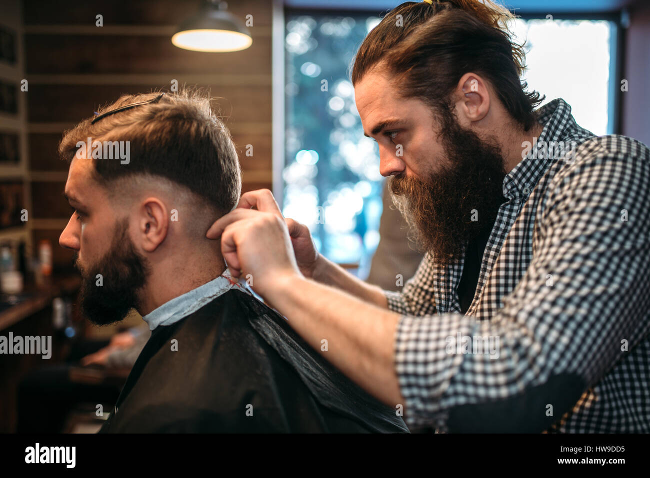 Hairdresser cutting hairstyle of the client man in black salon cape,  barbershop on background Stock Photo - Alamy