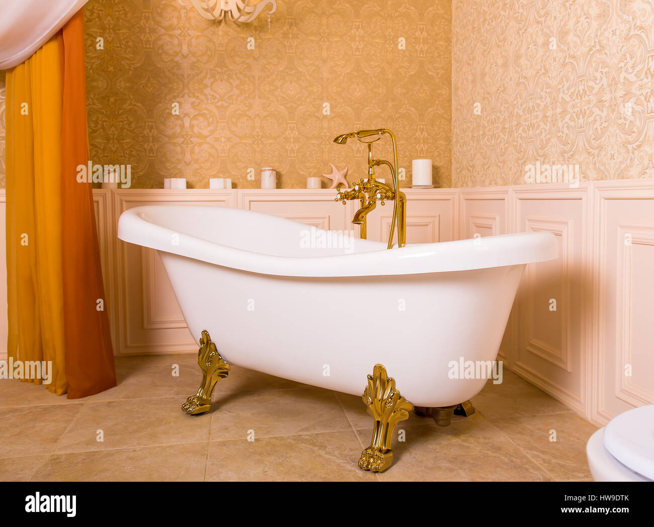 Rich bath with roll-tops in the form of animal paws and gold faucet in the bathroom. Luxury sanitary equipment Stock Photo