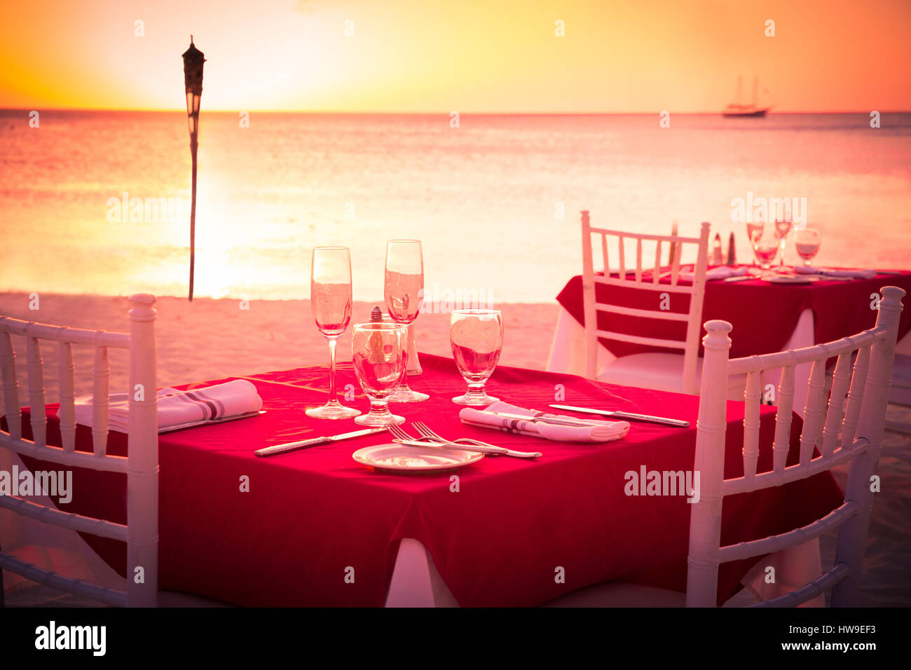 Table on beach set for romantic sunset dinner Stock Photo Alamy