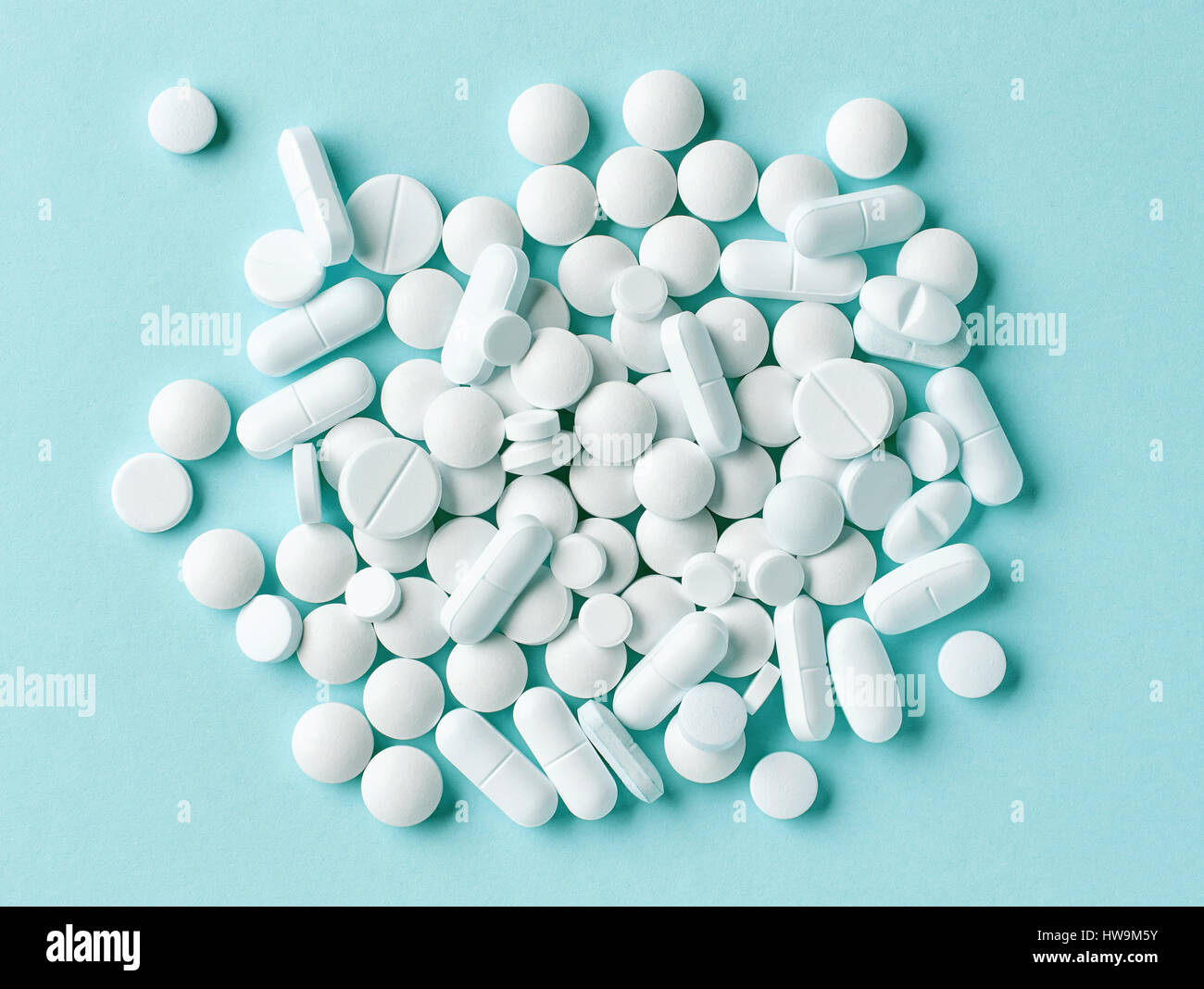 various white pills on blue background, top view Stock Photo
