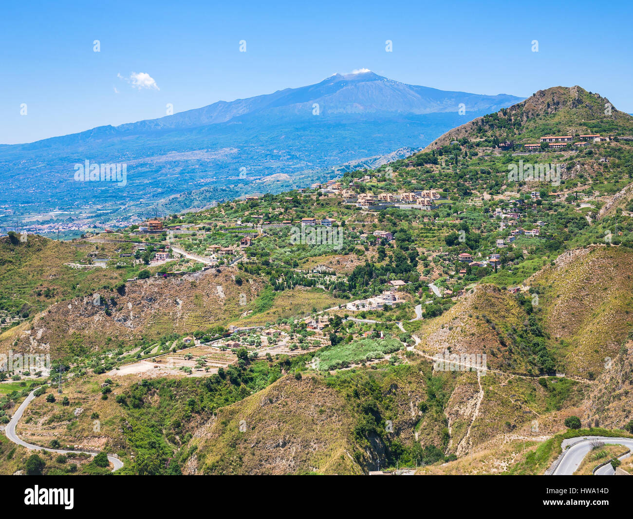 travel to Italy - view of green hills with villages and Etna volcano in Sicily Stock Photo