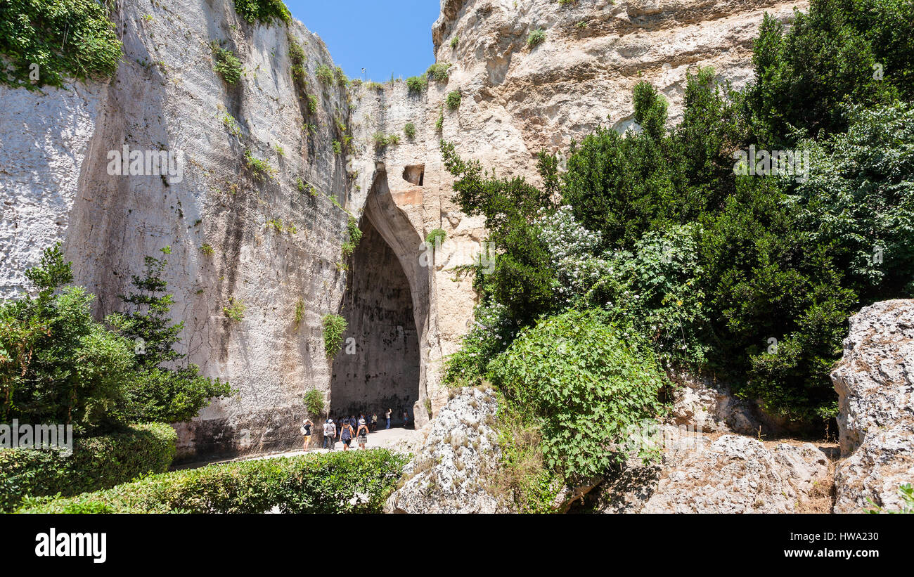 travel to Italy - tourists near Orecchio di Dionisio (Ear of Dionysius) cave in Temenites Hill in latomie del paradiso area of Archaeological Park of  Stock Photo