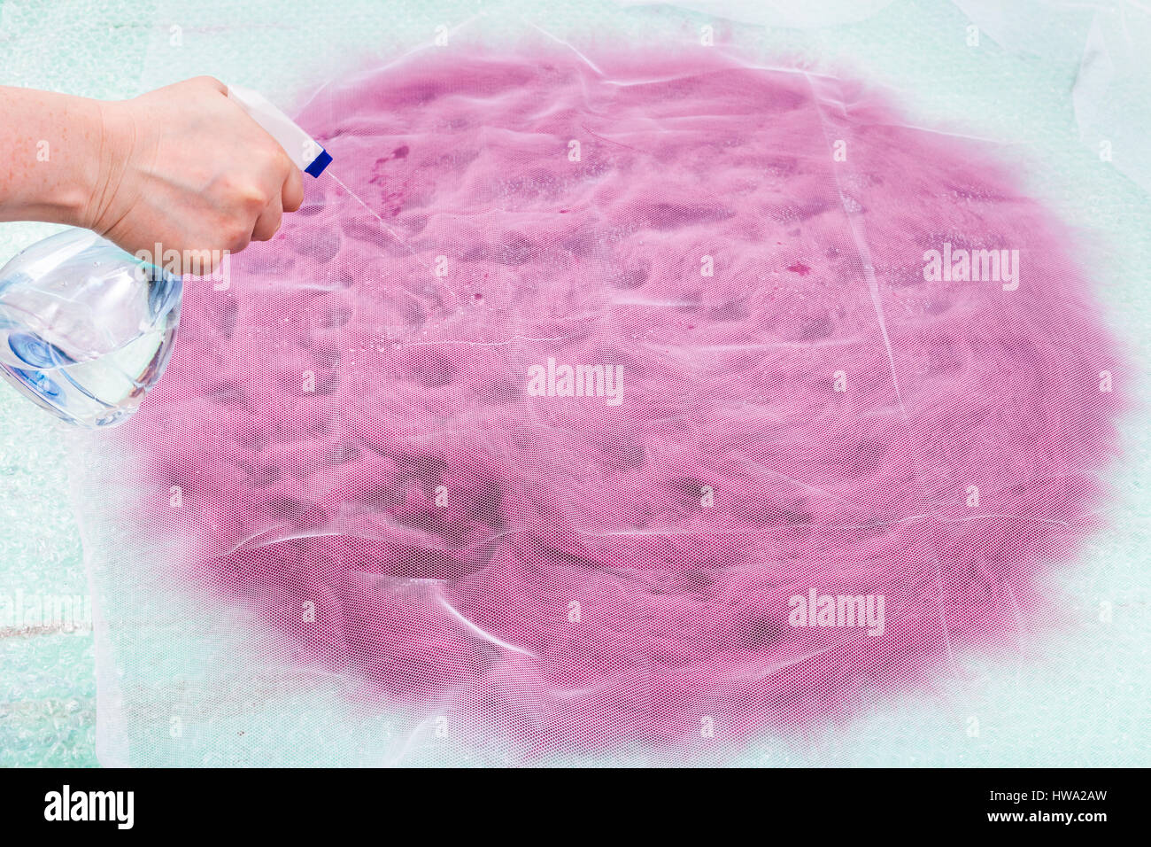 milliner wets the wool fibers on hat 