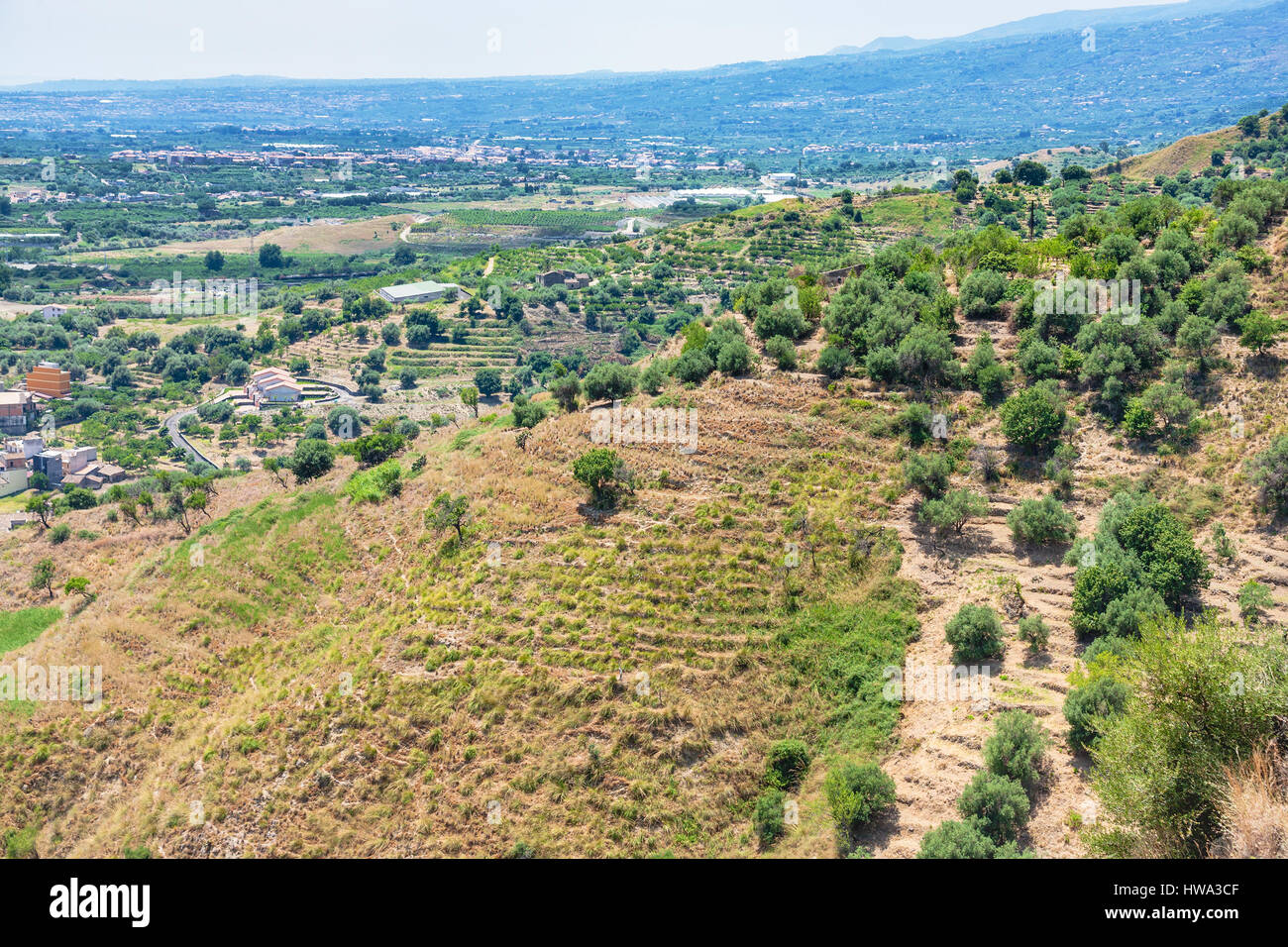 travel to Italy - green mountain slope near Calatabiano town in Sicily Stock Photo
