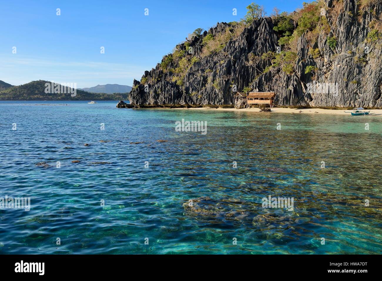 Philippines, Calamian Islands in northern Palawan, Coron Island Natural Biotic Area, Banul Beach under walls of limestone cliffs Stock Photo