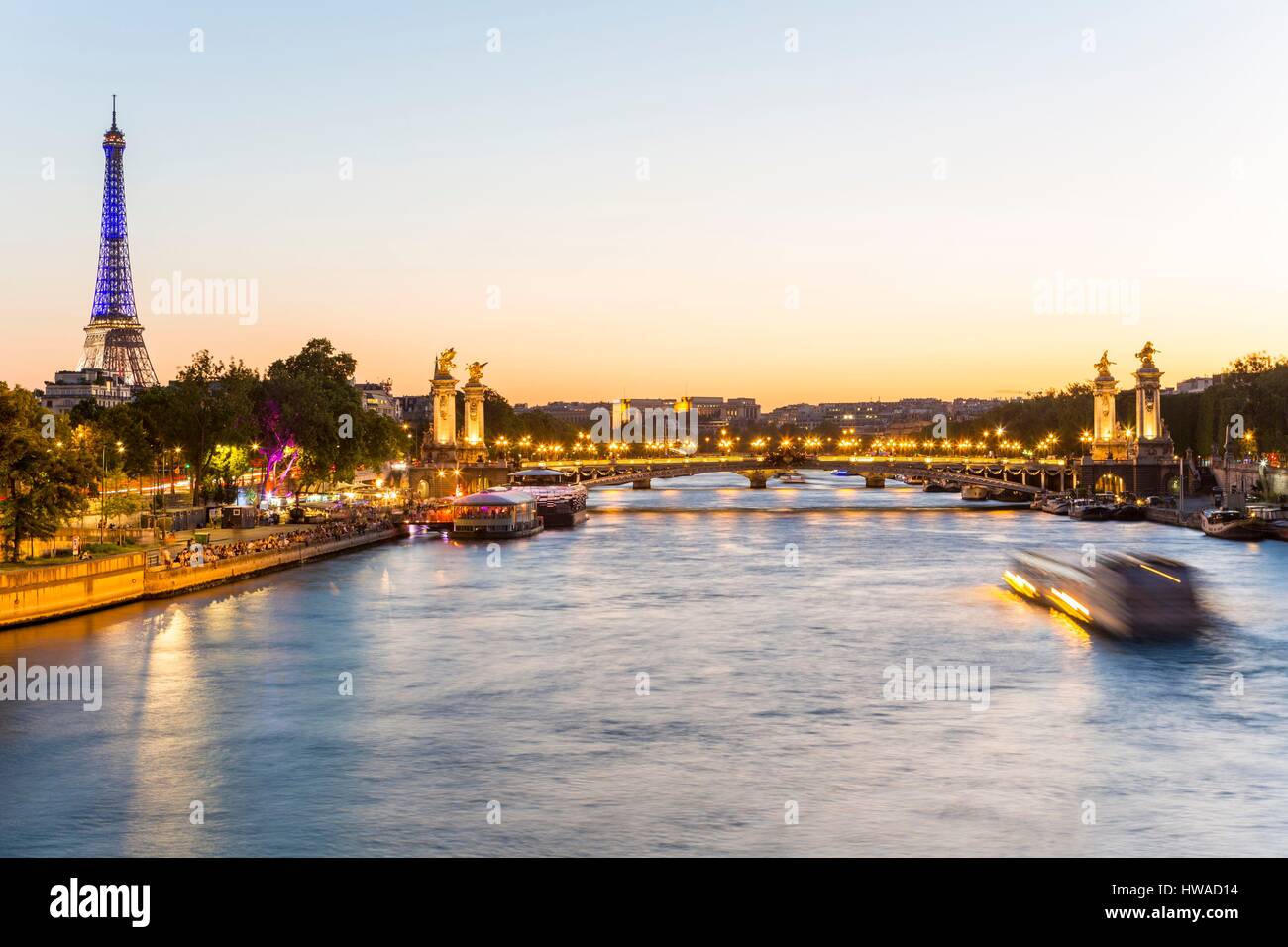 France, Paris, area listed as World Heritage by UNESCO, the New Berges at Quai d'Orsay with Eifflel Tower illuminated in blue white red (© SETE-illumi Stock Photo