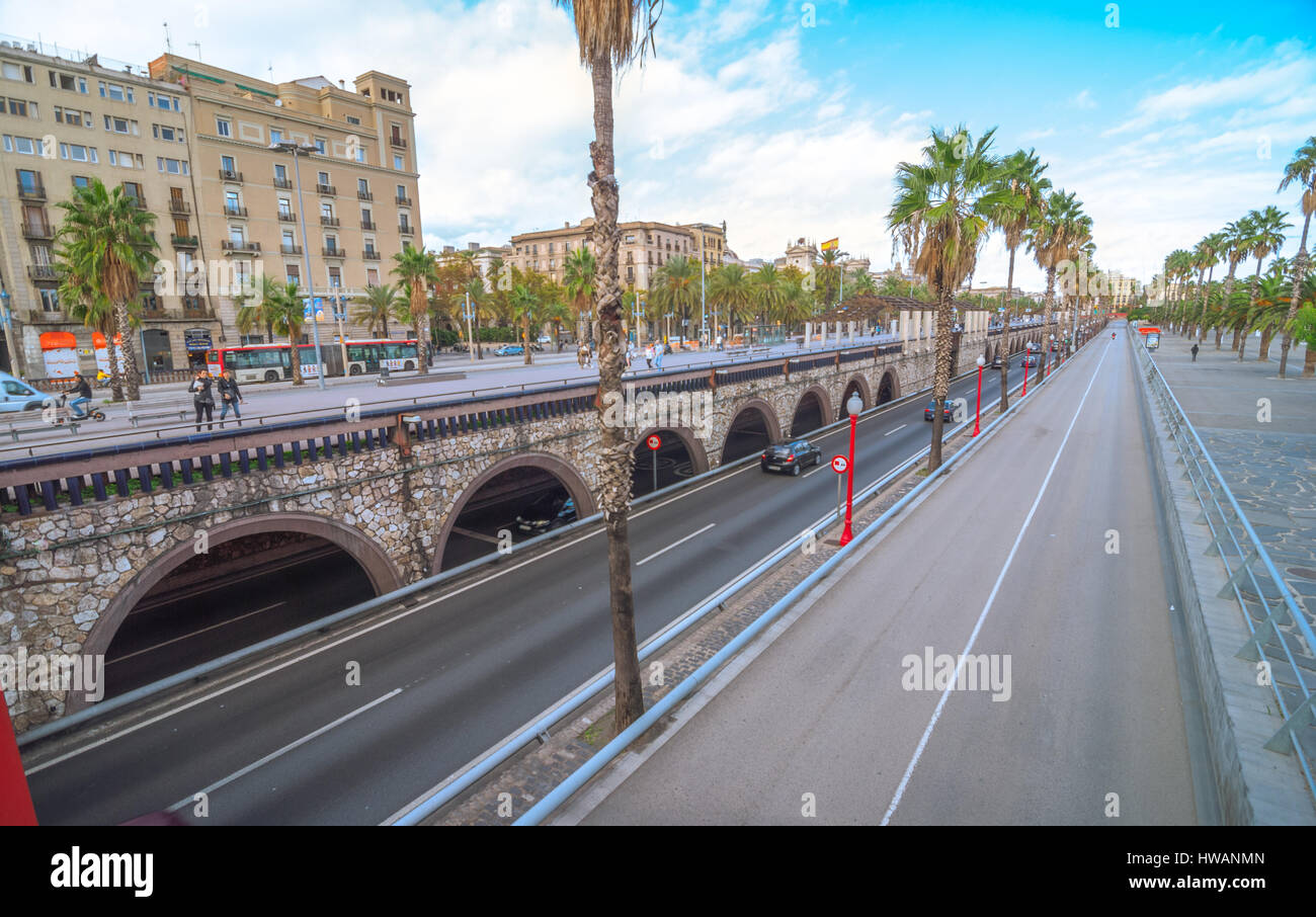 Barcelona, Spain, Nov 3rd, 2013:  Tourism in Spain.   Off season traffic in tunnelled streets & pedestrian traffic above as people enjoy warm outdoors Stock Photo