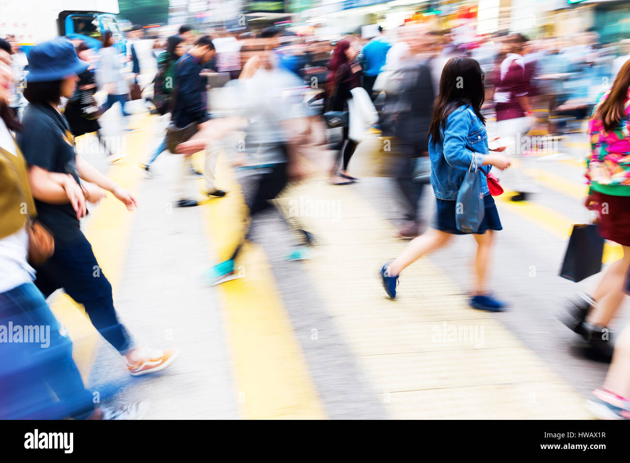 picture with motion blur of a crowd of people crossing a street in ...