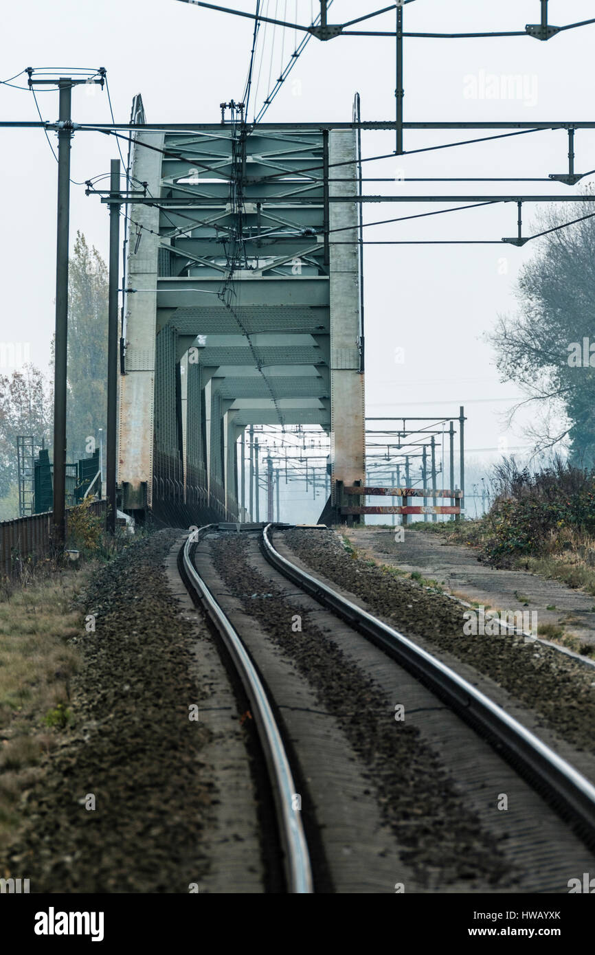 single-track lead into an old steel railway bridge Stock Photo