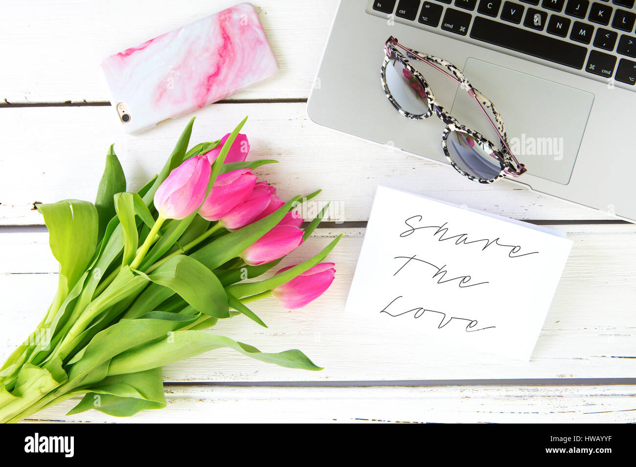 Share the Love message with pink tulips on a white wooden background Stock Photo