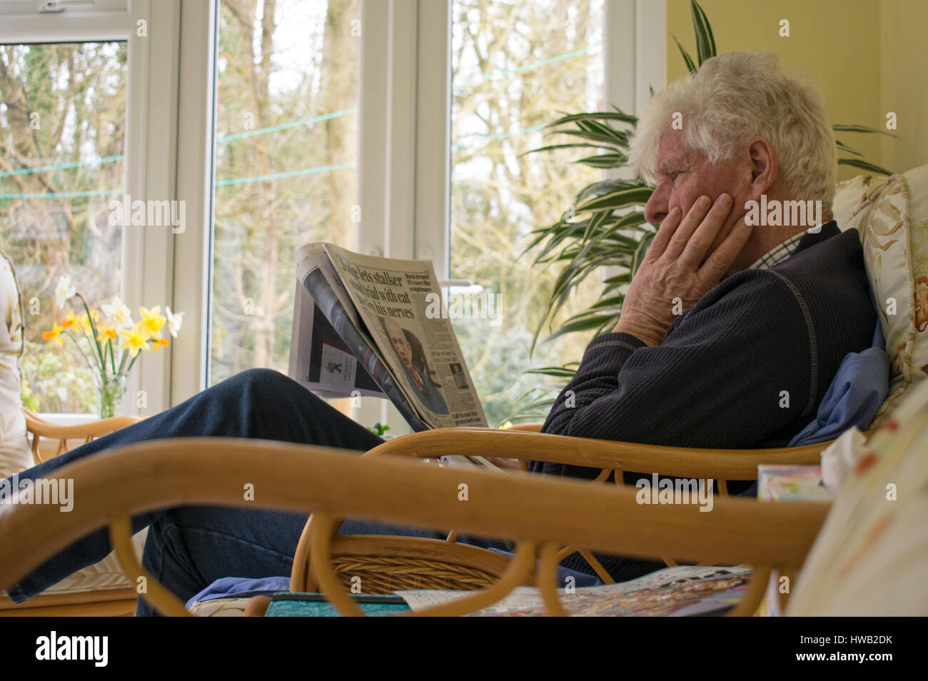 Elderly man reading newspaper Stock Photo