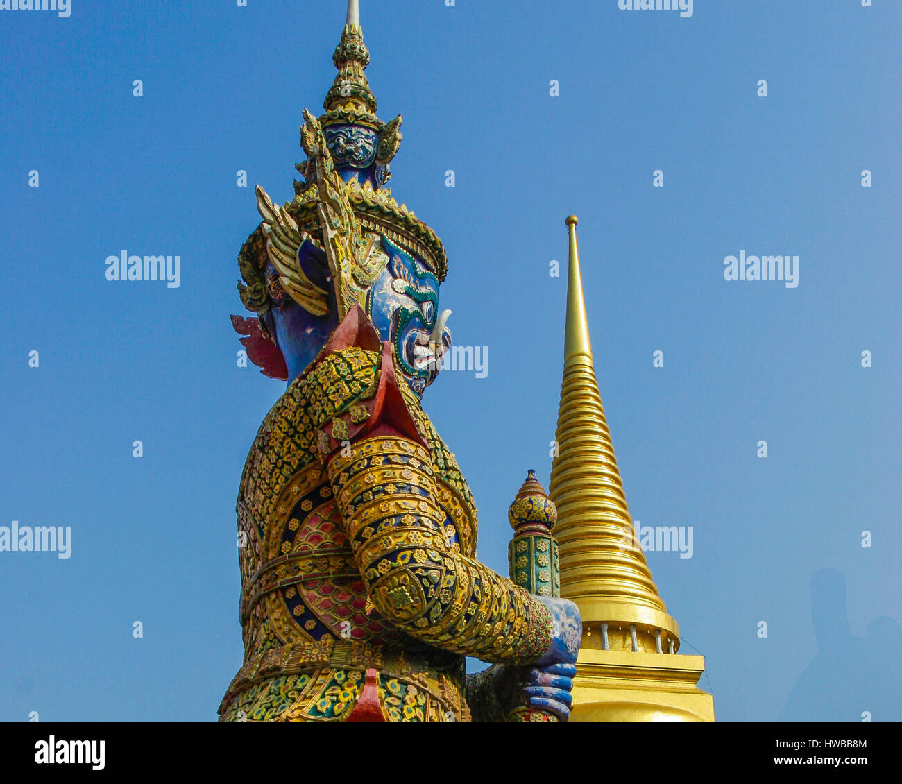 November 14, 2006 - Bangkok, Thailand - A gate-keeping Giant (Yaksa Tavambal) in a costume of colored glazed tiles, 6 m. (19 Â½ ft) tall, guard the entrance to The Gallery (Phra Rabiang) of the most sacred Temple of the Emerald Buddha (Wat Phra Kaew) in the Grand Palace Complex, Bangkok, Thailand. Thailand has become a favorite tourist destination. (Credit Image: © Arnold Drapkin via ZUMA Wire) Stock Photo