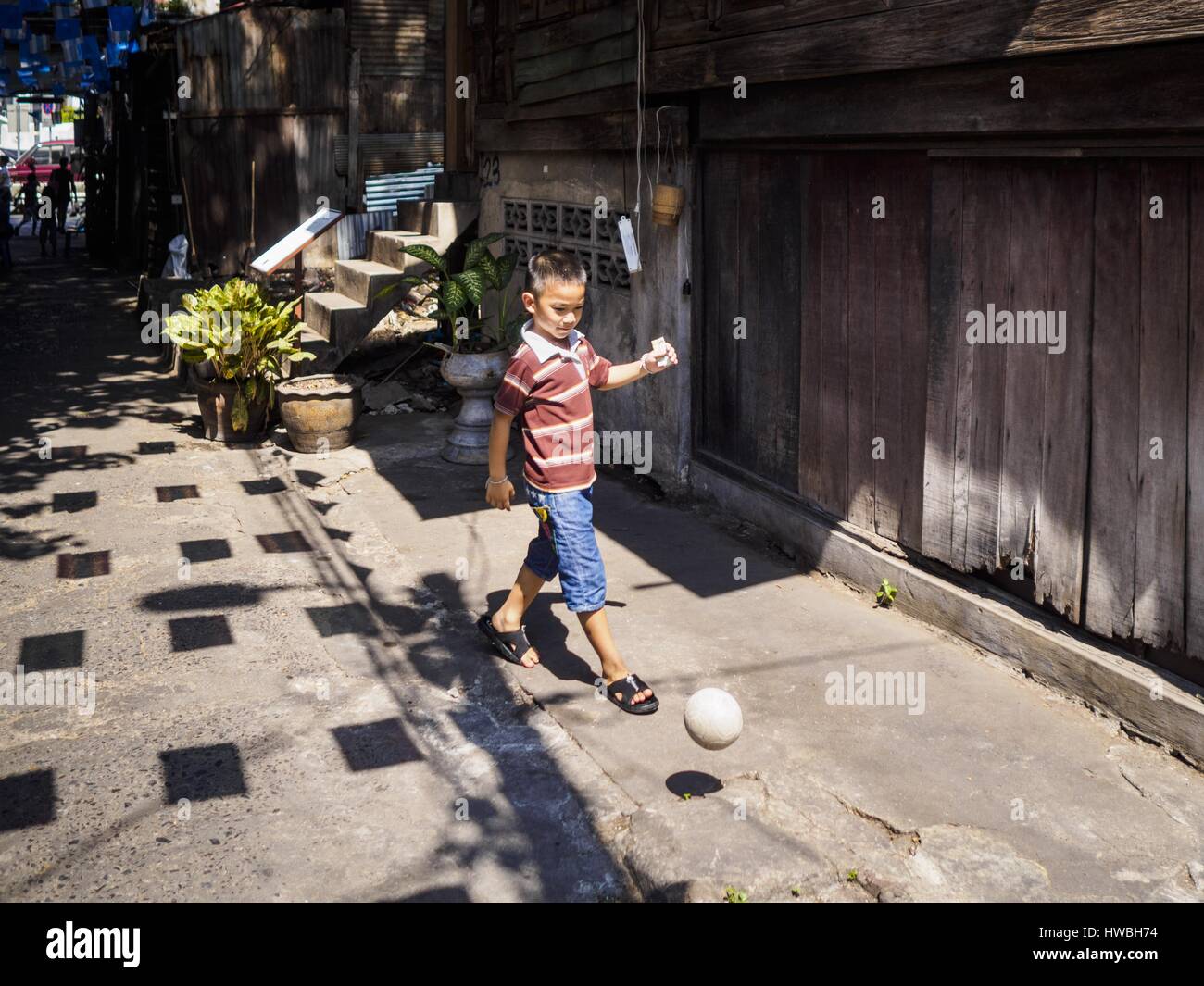 Bangkok, Bangkok, Thailand. 20th Mar, 2017. A boy plays with a plastic ball on a sidewalk in Pom Mahakan. The final evictions of the remaining families in Pom Mahakan, a slum community in a 19th century fort in Bangkok, have started. City officials are moving the residents out of the fort. NGOs and historic preservation organizations protested the city's action but city officials did not relent and started evicting the remaining families in early March. Credit: Jack Kurtz/ZUMA Wire/Alamy Live News Stock Photo