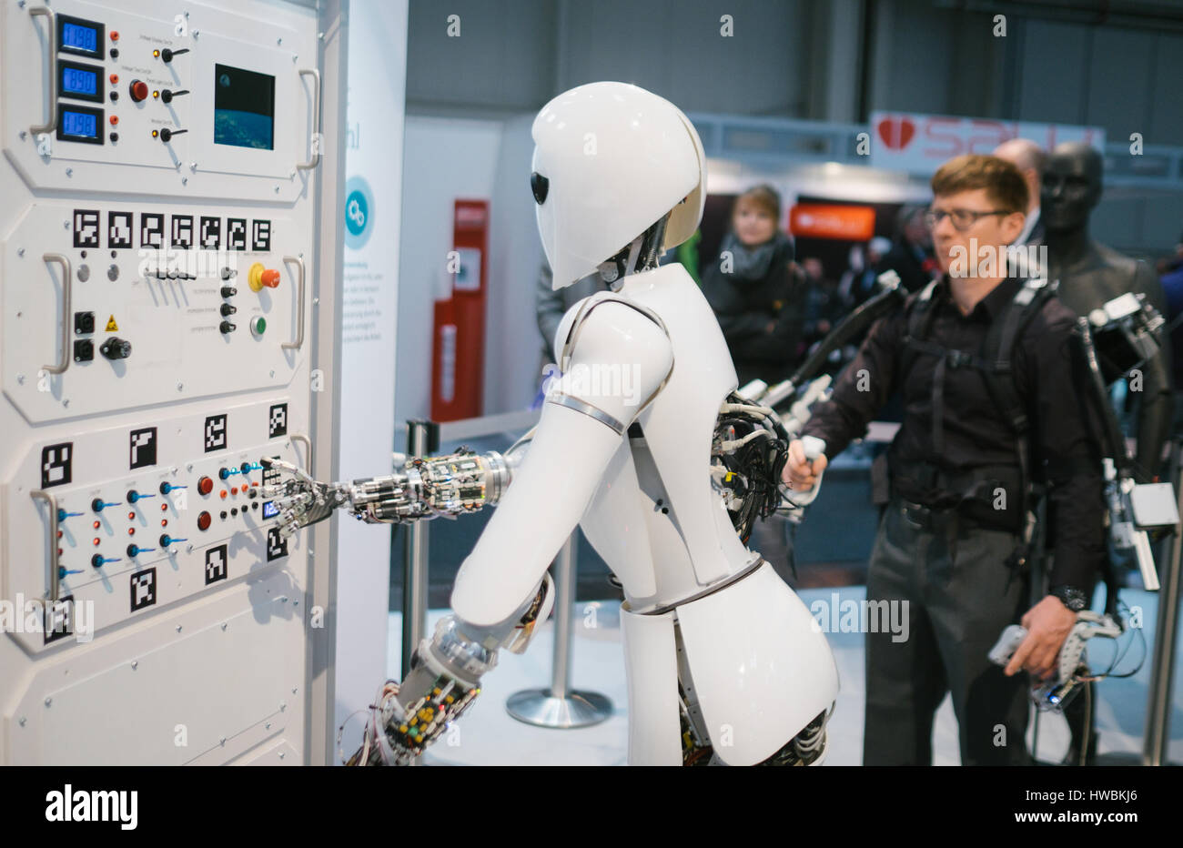 Hanover, Germany. 20th Mar, 2017. An employee of Robotic Innovation Center controls the robot AILA using an exoskeleton at the stand of the German Research Center for Artificial Intelligence (DFKI) at the CeBIT fair in Hanover, Germany, 20 March 2017. The IT fair CeBIT opens on 20 March 2017 and wants to convince its audience with specific application examples of new technologies. More than 3,000 exhibitors from 70 countries expect roughly 200,000 visitors at the five-day show from 20 to 24 March. Photo: Ole Spata/dpa/Alamy Live News Stock Photo