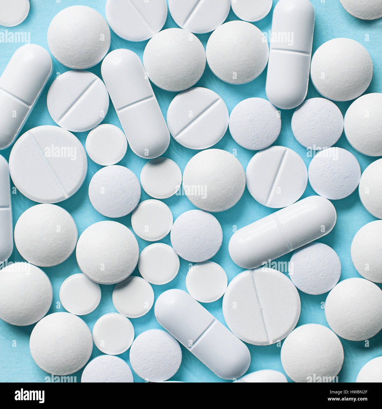 white pills on blue background, top view Stock Photo