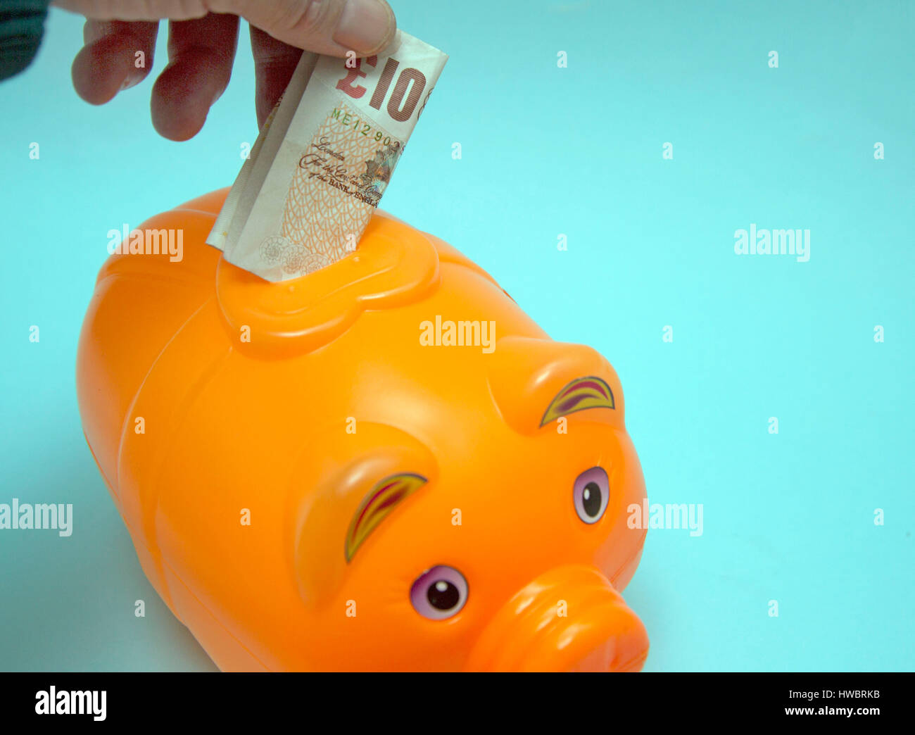 Placing banknote in money box, London Stock Photo Alamy