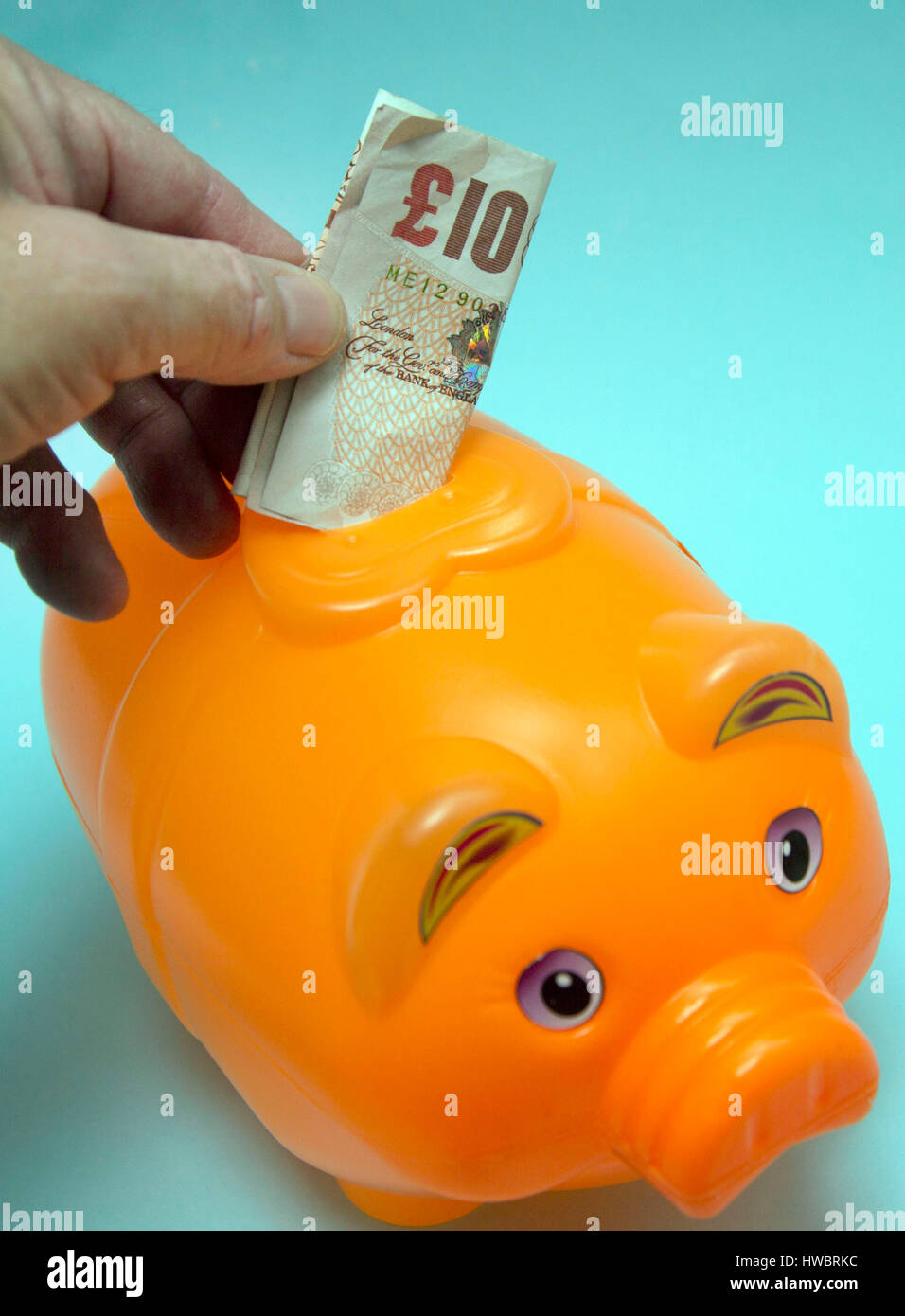 Placing banknote in money box, London Stock Photo Alamy