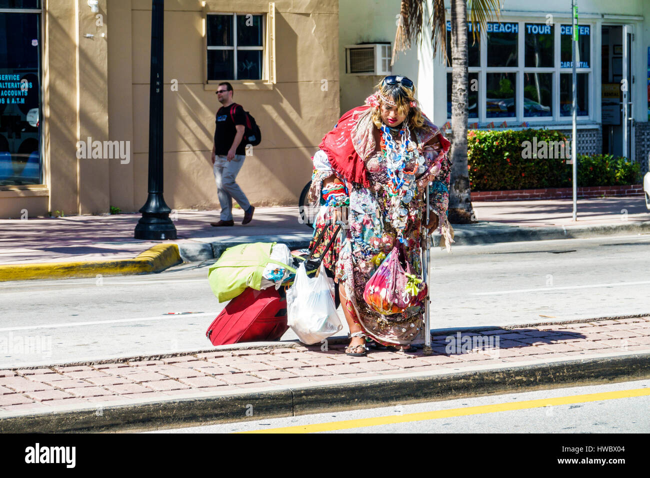 Miami Beach Florida,Washington Avenue,woman female women,bag lady,young adult,homeless,indigent,street person,eccentric,rolling luggage,FL170205004 Stock Photo