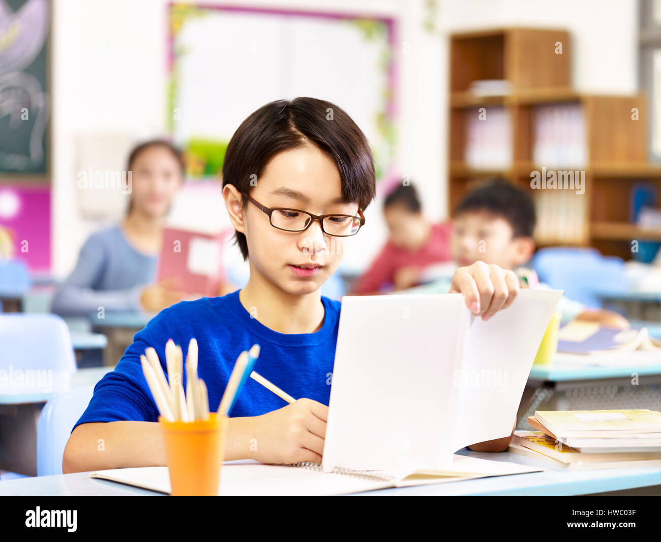 asian primary school student with glasses studying in class. Stock Photo
