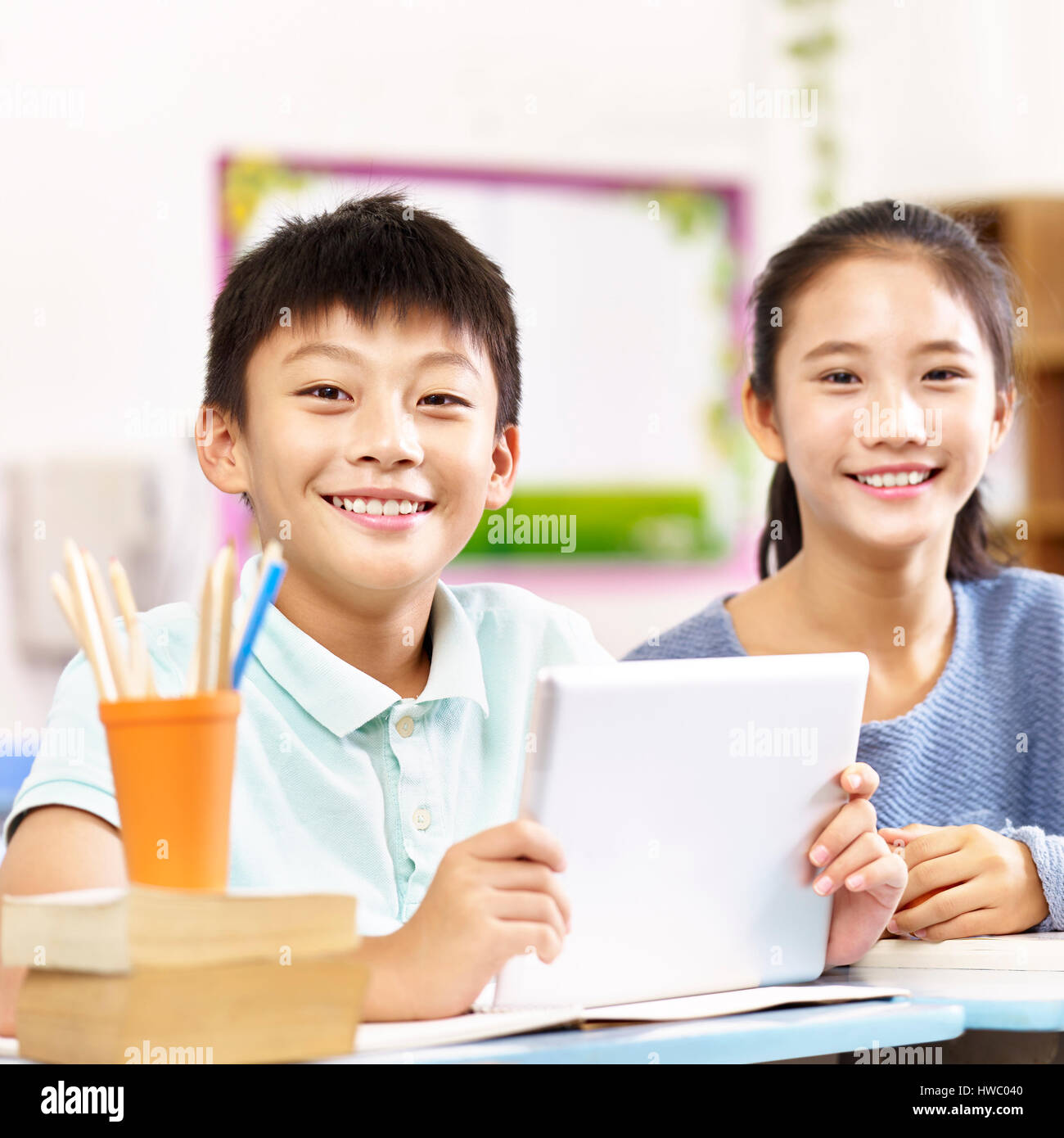portrait of two happy asian primary school students looking at camera smiling. Stock Photo