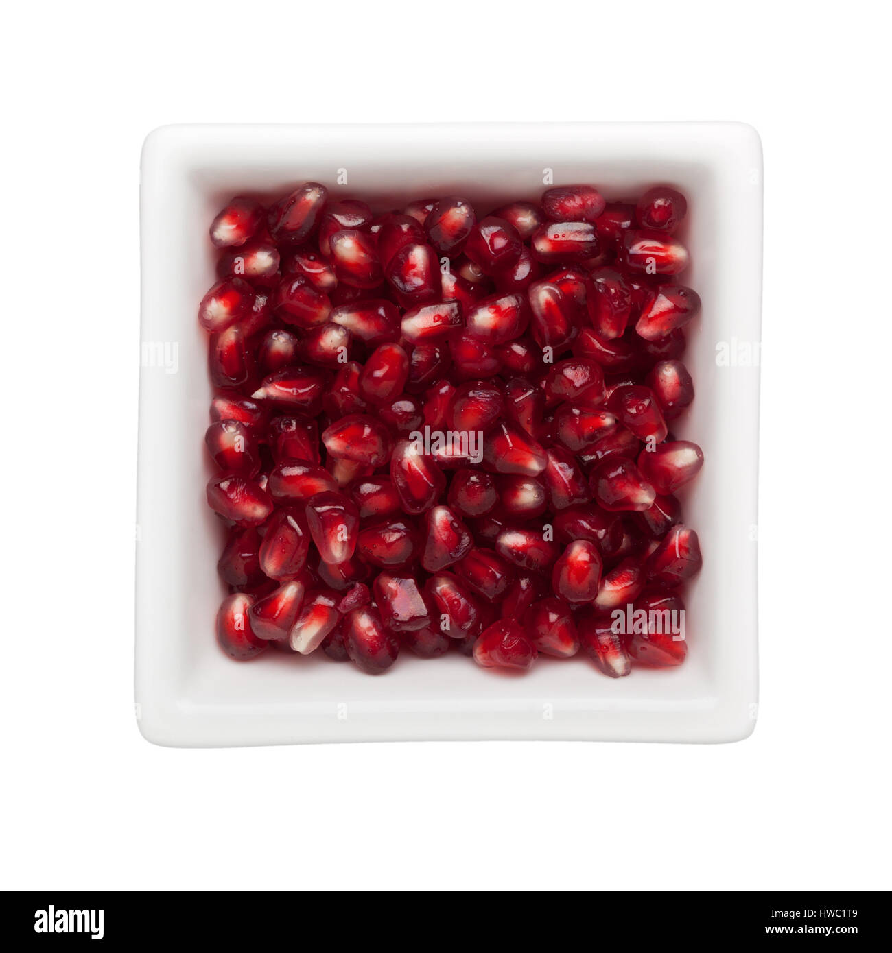 Pomegranate arils in a square bowl isolated on white background Stock Photo